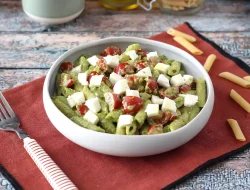 Cold pasta with arugula pesto, cherry tomatoes, and mozzarella: a fresh summer delight
