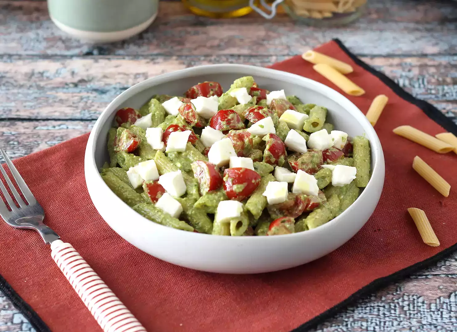 Cold pasta with arugula pesto, cherry tomatoes, and mozzarella: a fresh summer delight